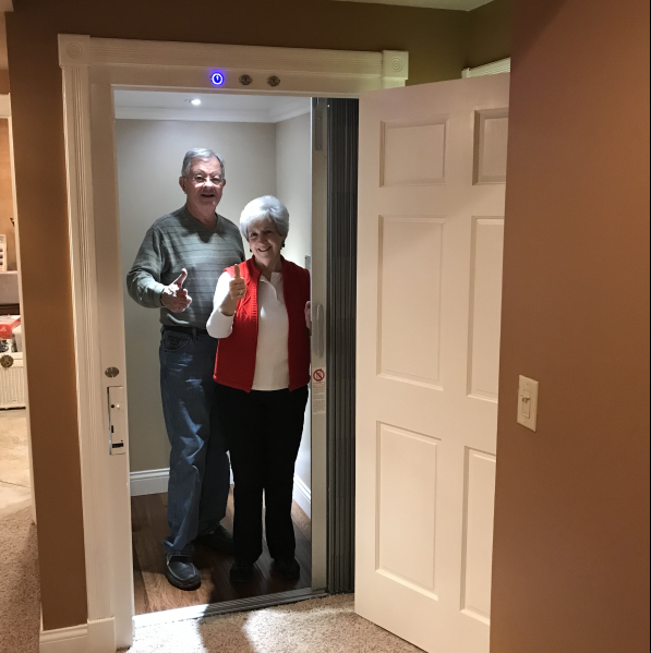 man and woman standing inside a residential elevator